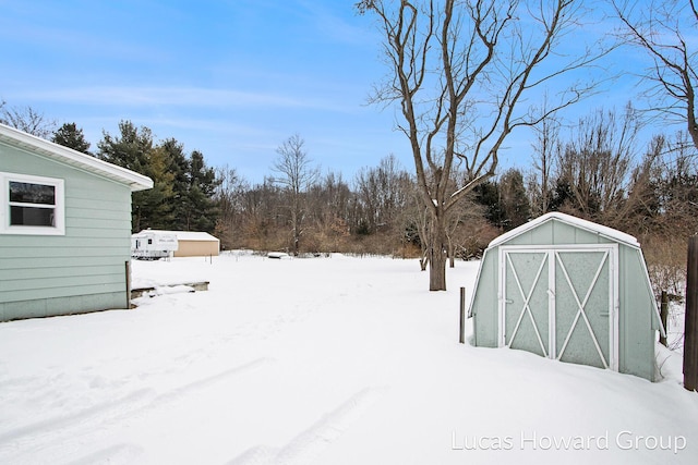 yard covered in snow with an outbuilding and a storage unit