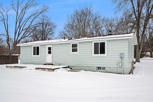 ranch-style house with metal roof and fence