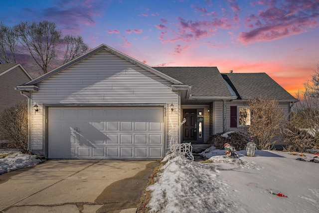 ranch-style house featuring an attached garage, a shingled roof, and concrete driveway