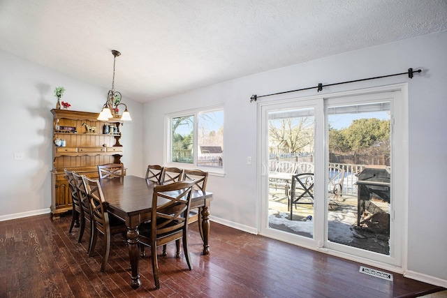 dining room featuring baseboards, visible vents, dark wood-type flooring, vaulted ceiling, and a textured ceiling