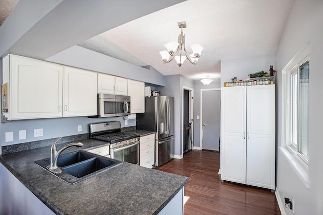 kitchen with dark countertops, stainless steel appliances, and a sink