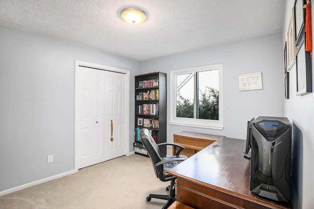 office area with baseboards, a textured ceiling, and light colored carpet