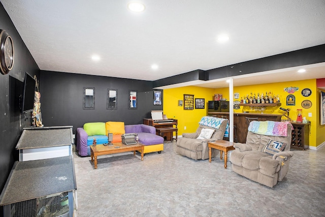 living room featuring recessed lighting, baseboards, and a bar