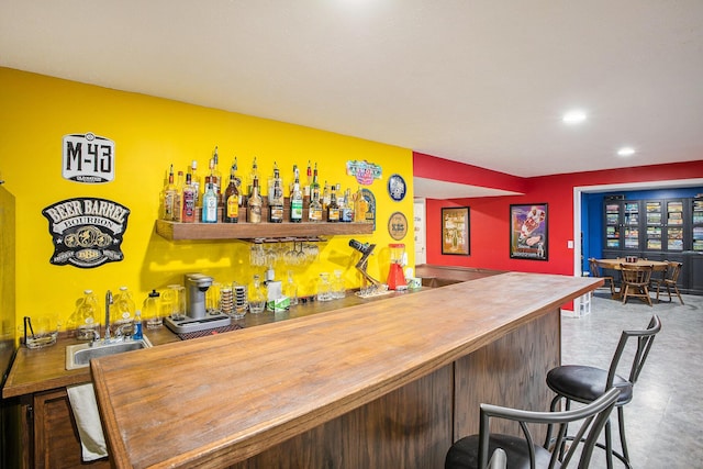 bar featuring a bar, a sink, and recessed lighting