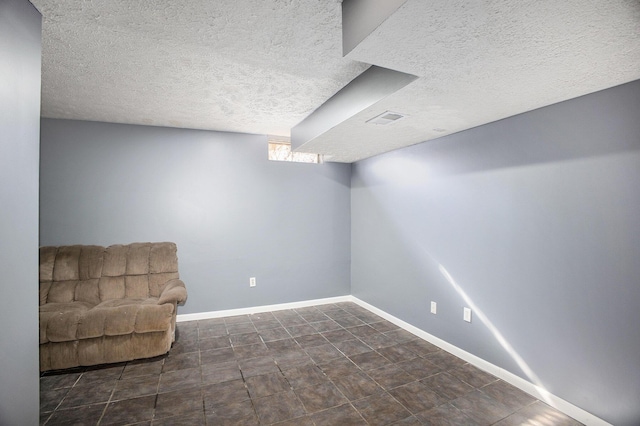 below grade area with a textured ceiling and baseboards