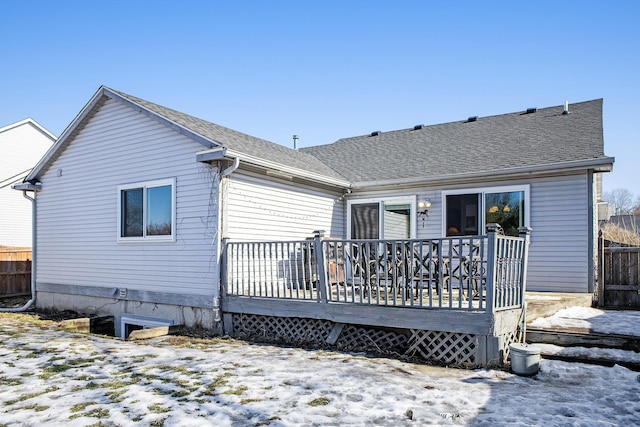 snow covered house featuring a deck and a shingled roof