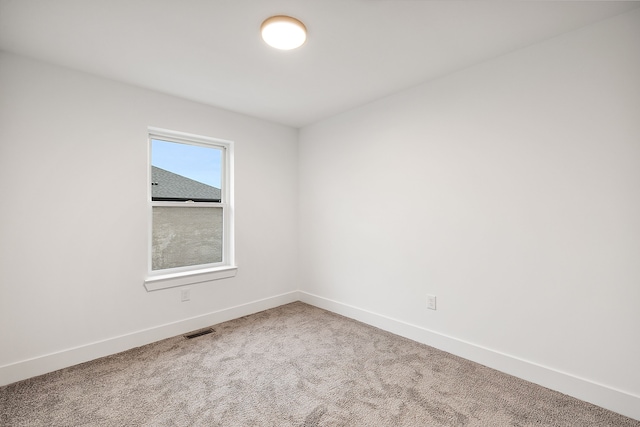 carpeted empty room featuring visible vents and baseboards