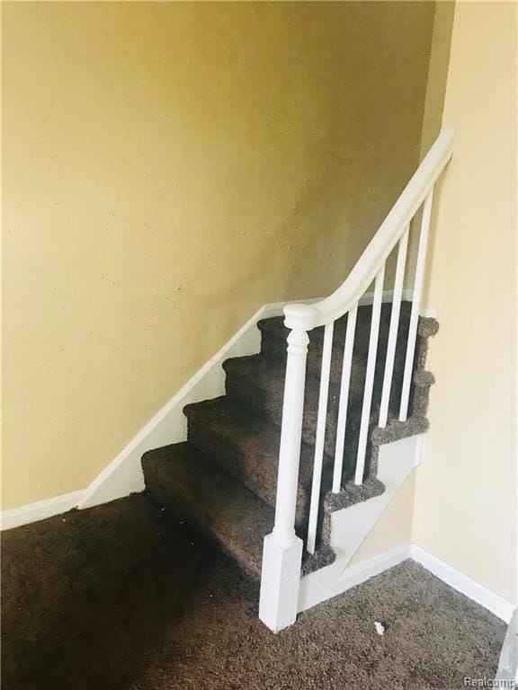 stairs with carpet floors and baseboards