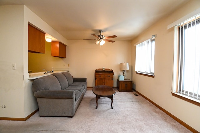 living room with light carpet, ceiling fan, visible vents, and baseboards