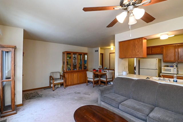 living room with light carpet, ceiling fan, and baseboards