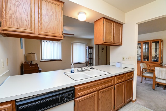 kitchen with light countertops, brown cabinetry, white dishwasher, a sink, and a peninsula