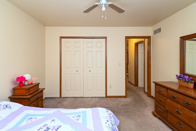 bedroom with light colored carpet, a ceiling fan, baseboards, visible vents, and a closet