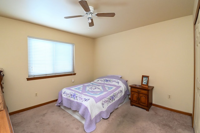 bedroom with light carpet, baseboards, and a ceiling fan