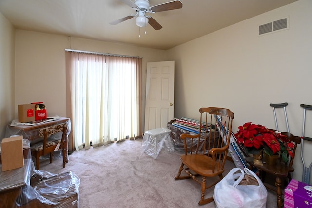 miscellaneous room with visible vents, a ceiling fan, and light colored carpet