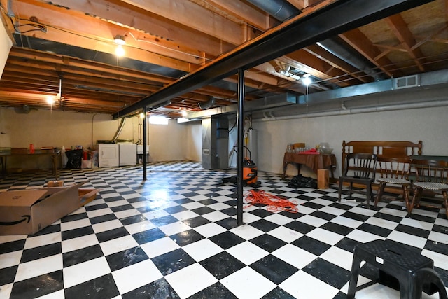 unfinished below grade area featuring separate washer and dryer, gas water heater, visible vents, and tile patterned floors