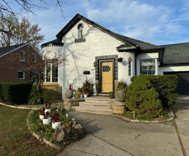 french provincial home with a garage and concrete driveway