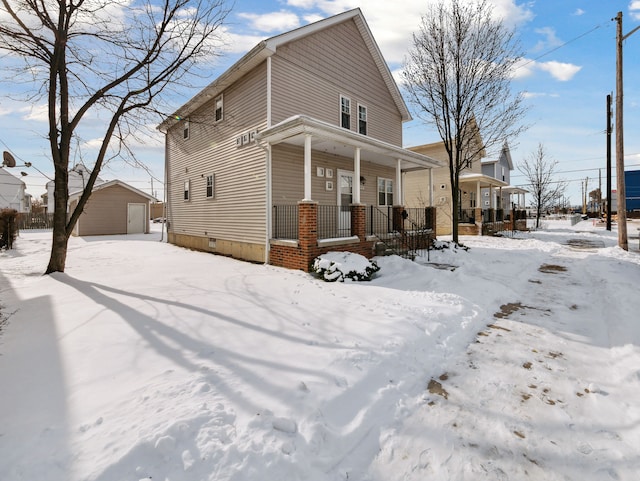 view of front of property with a garage, covered porch, and an outdoor structure