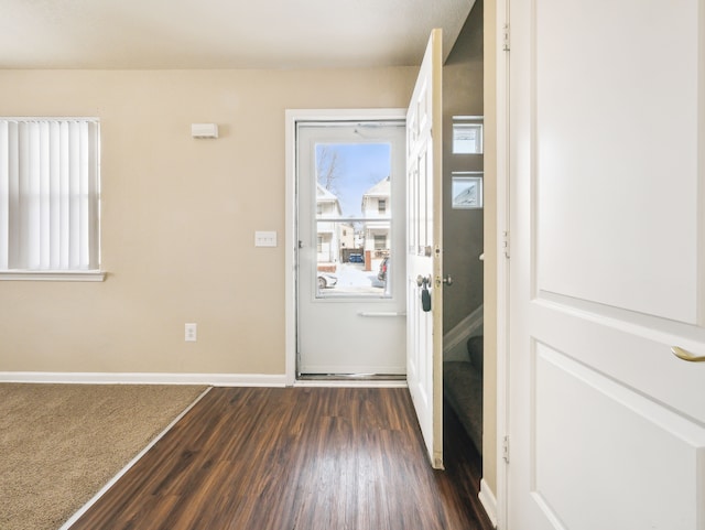 doorway to outside featuring dark wood-style flooring and baseboards