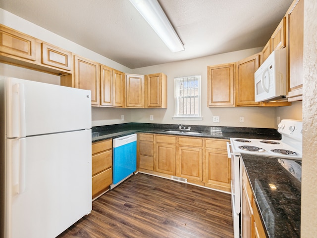 kitchen with white appliances, visible vents, dark wood finished floors, light brown cabinets, and a sink