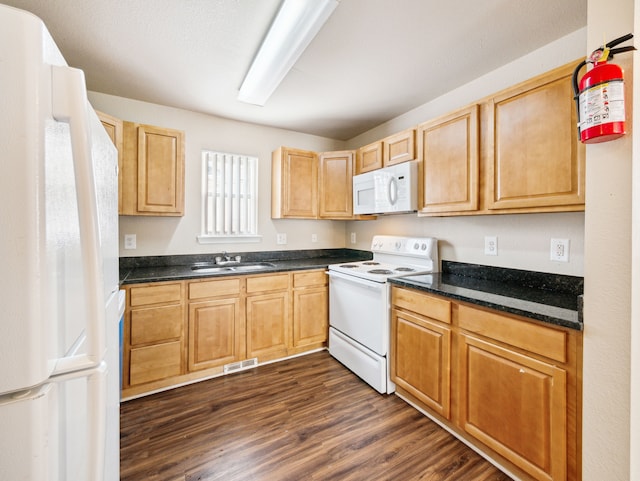 kitchen with dark wood-style floors, white appliances, a sink, and visible vents