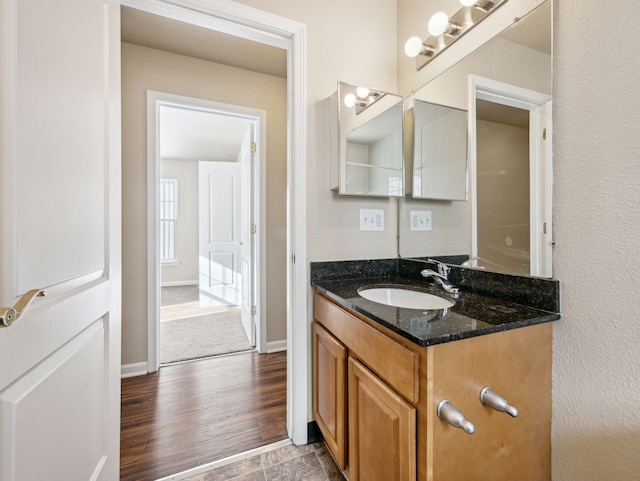 bathroom with vanity, baseboards, and wood finished floors