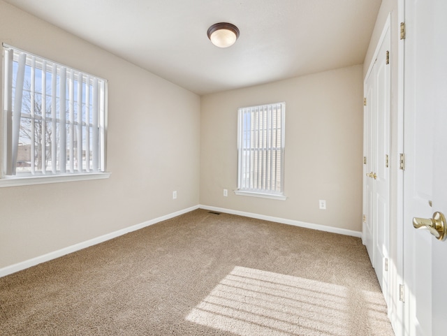 unfurnished bedroom with carpet floors and baseboards