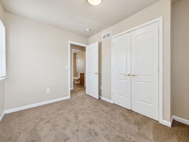 unfurnished bedroom with baseboards, a closet, visible vents, and carpet flooring