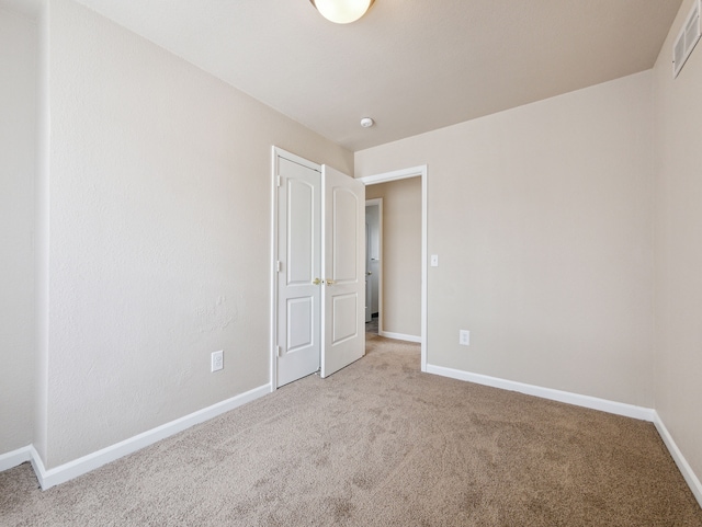 unfurnished bedroom featuring carpet, visible vents, and baseboards