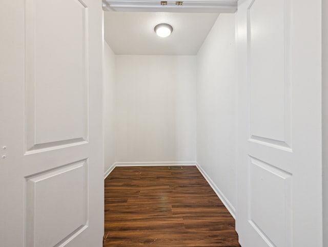 interior space featuring baseboards and dark wood-type flooring