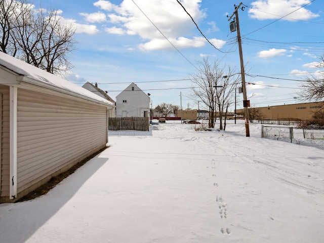 yard covered in snow featuring fence