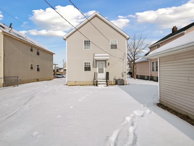 snow covered back of property with central AC