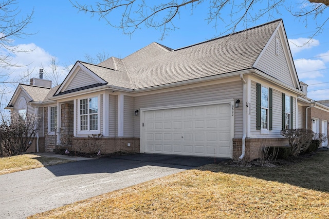 view of home's exterior featuring roof with shingles, a chimney, driveway, a yard, and an attached garage