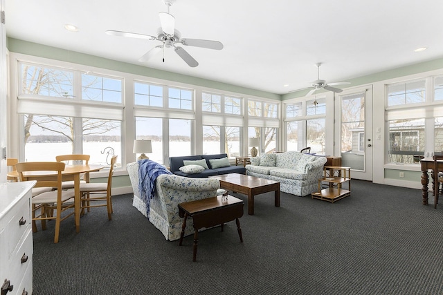 sunroom / solarium featuring a water view and a ceiling fan