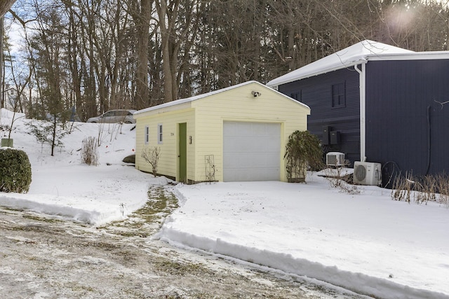 snow covered garage with a detached garage