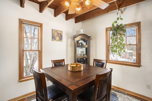 dining area featuring baseboards, plenty of natural light, visible vents, and beamed ceiling