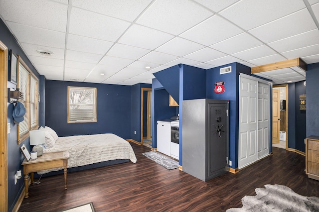 bedroom featuring dark wood-style floors, visible vents, and a drop ceiling