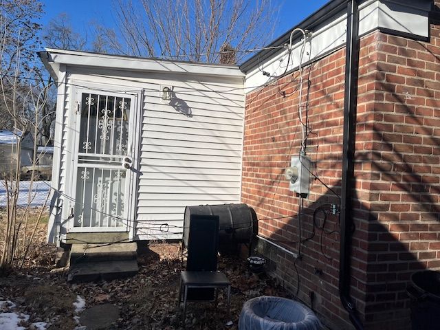 view of side of home featuring entry steps and brick siding