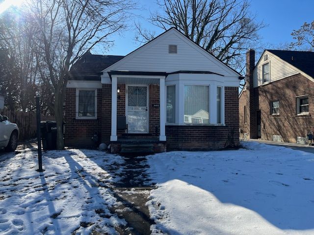 bungalow-style house with brick siding