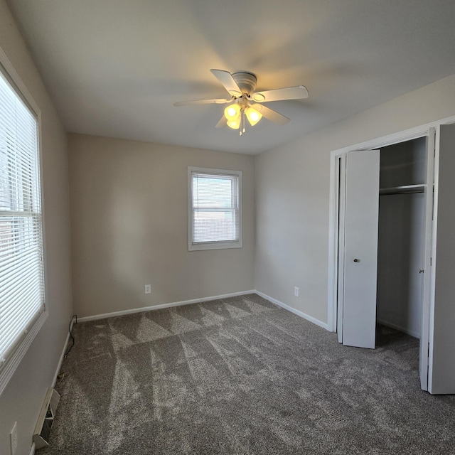 unfurnished bedroom featuring dark colored carpet, a closet, ceiling fan, and baseboards