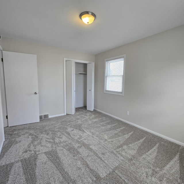 unfurnished bedroom with visible vents, a closet, baseboards, and carpet flooring