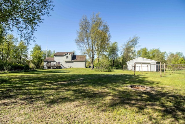 4898 Mount Morris Rd, Columbiaville, MI 48421 - view of yard with an outdoor fire pit, a garage, a wooden deck, and stairs