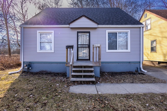 bungalow-style home with roof with shingles