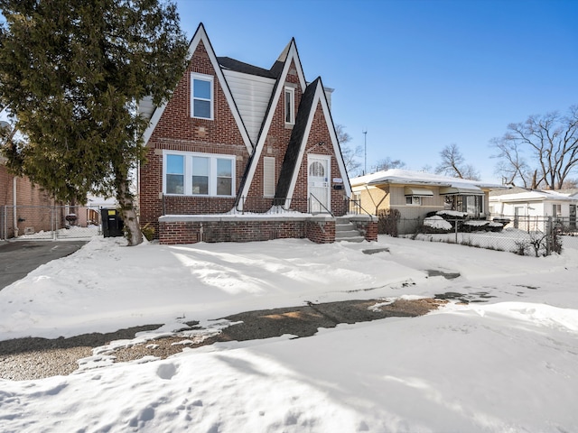 view of front of house featuring fence and brick siding