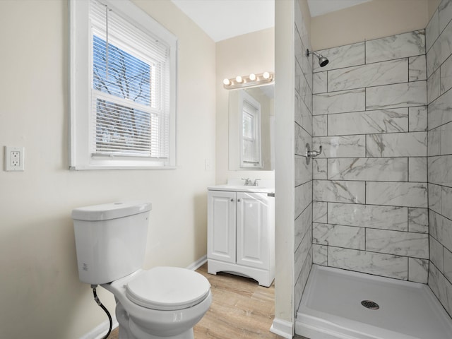 bathroom with toilet, wood finished floors, a shower stall, and vanity