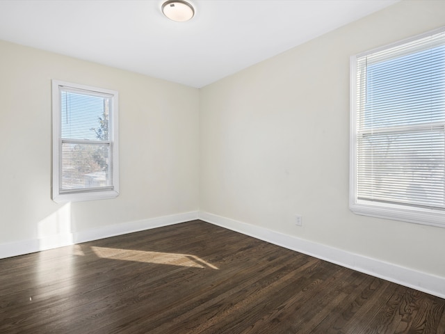 unfurnished room featuring dark wood-style flooring and baseboards