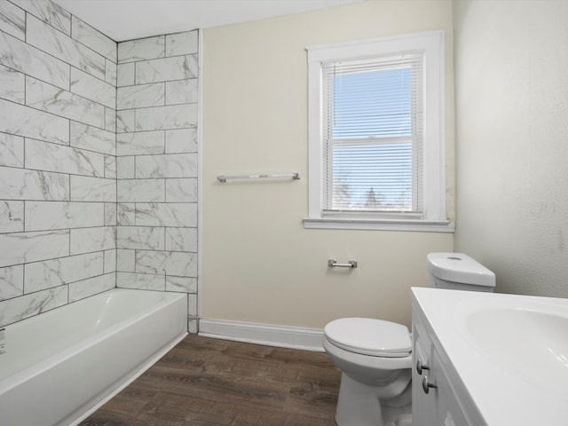 full bath featuring toilet, wood finished floors, vanity, bathing tub / shower combination, and baseboards