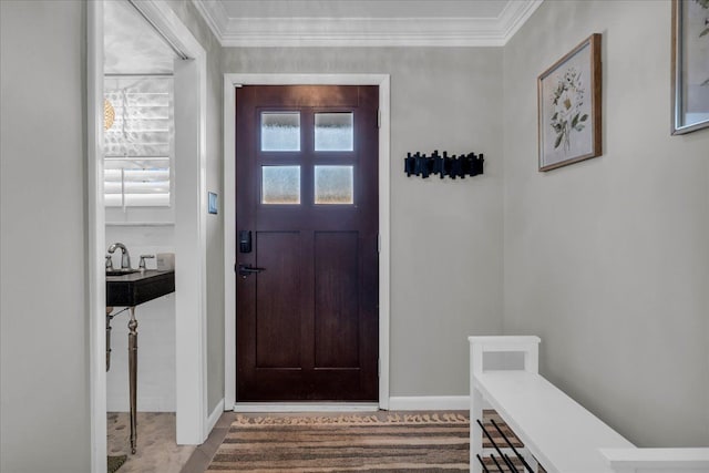 foyer with crown molding and baseboards