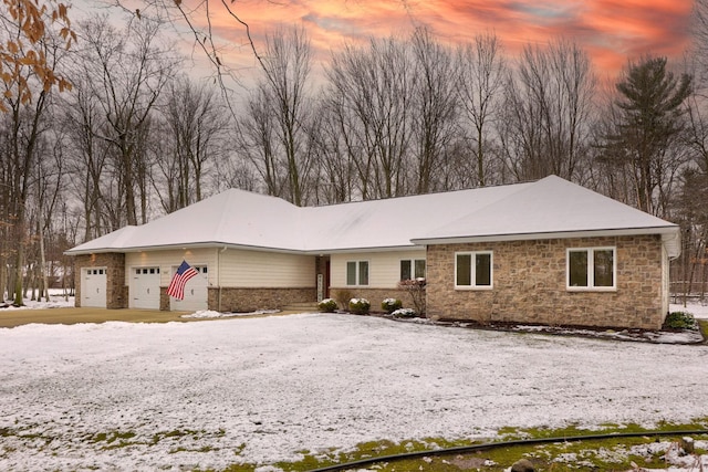 single story home with a garage and stone siding