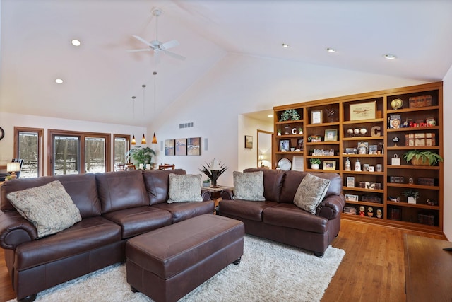 living room with ceiling fan, high vaulted ceiling, visible vents, and light wood-style floors