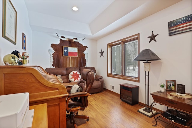 office area with light wood finished floors, recessed lighting, a raised ceiling, visible vents, and baseboards